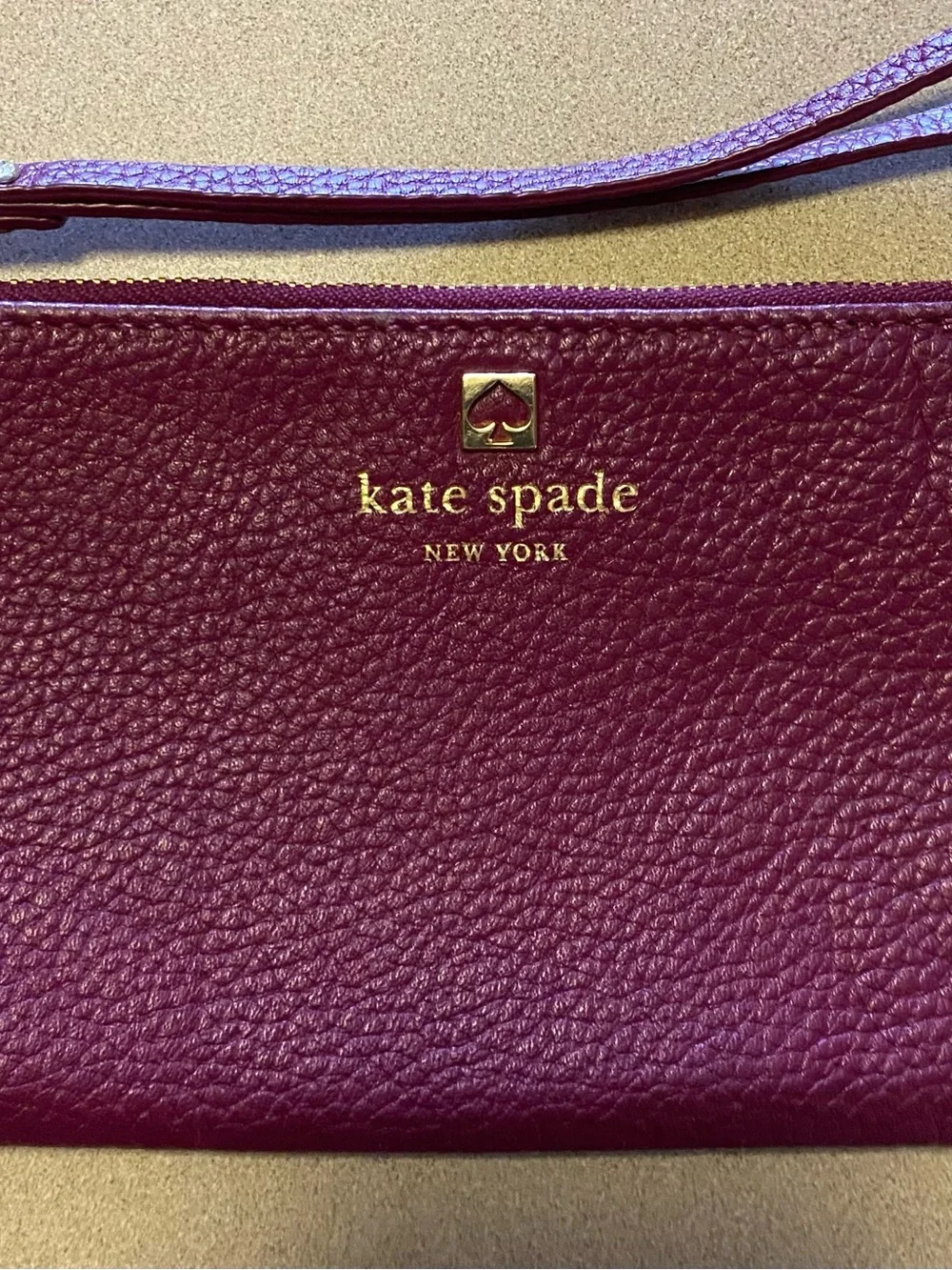 kate spade plum pebbled leather wristlet with gold logo
